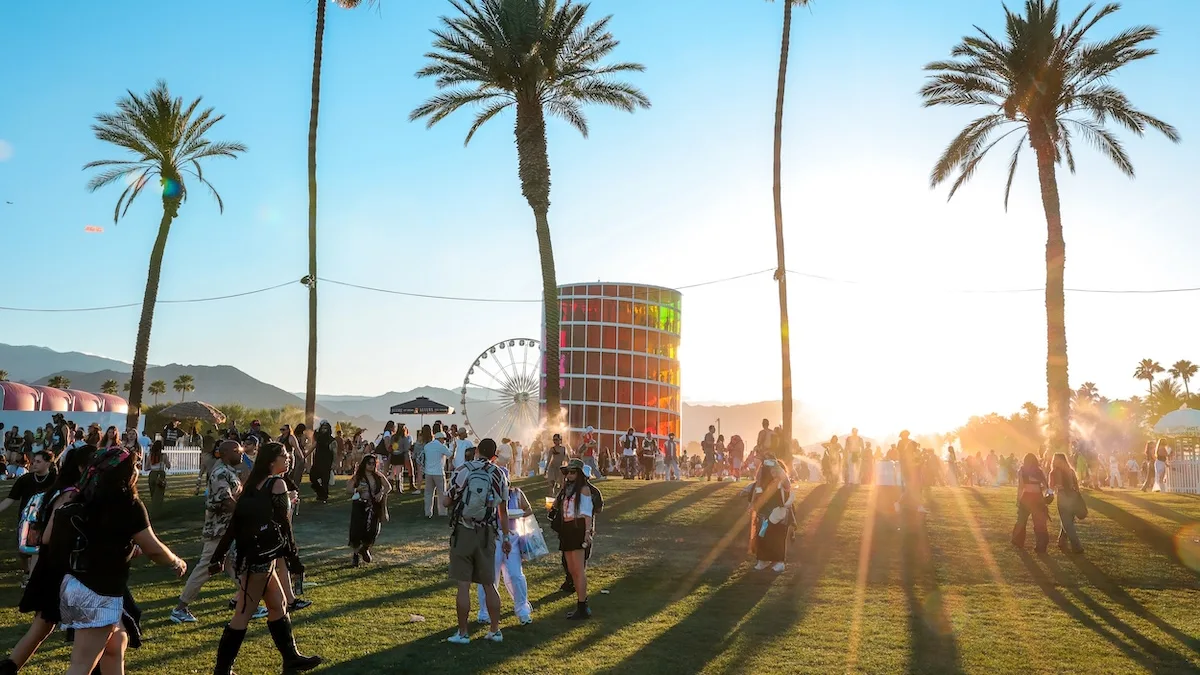 Festival grounds with multiple stages and a crowd under afternoon sun